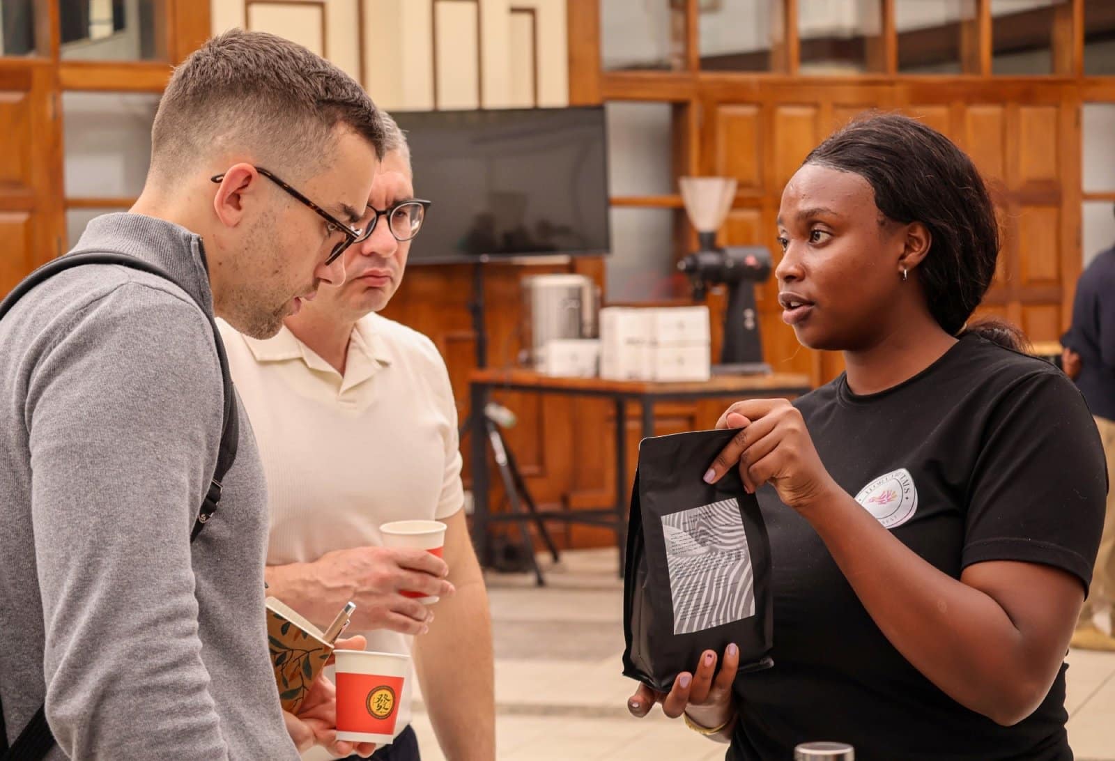 An EACMC exhibitor presenting packaged coffee to international visitors